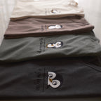 Stack of Desk Face embroidered t-shirts in four colors